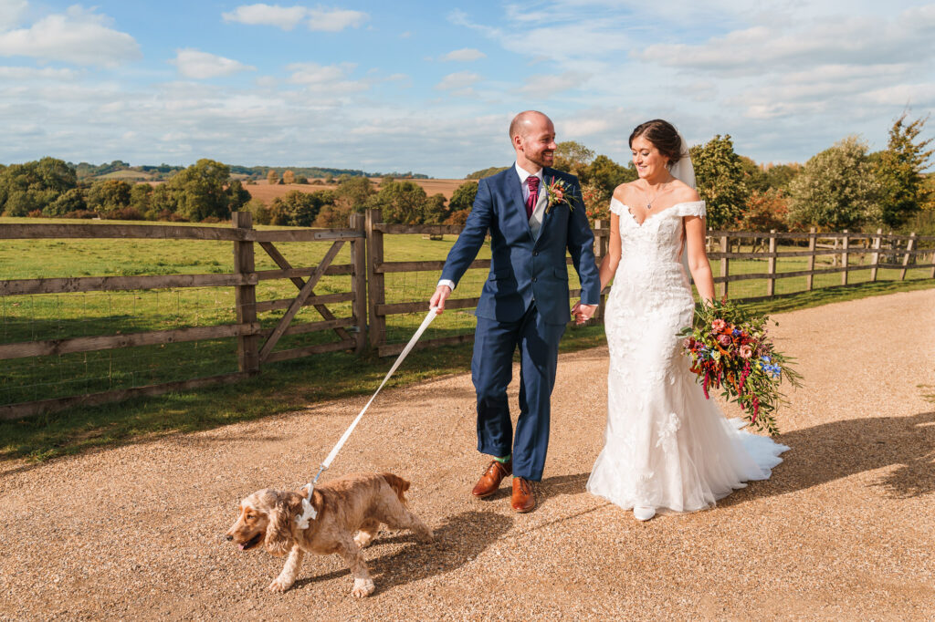 bride and groom take their dog for a walk